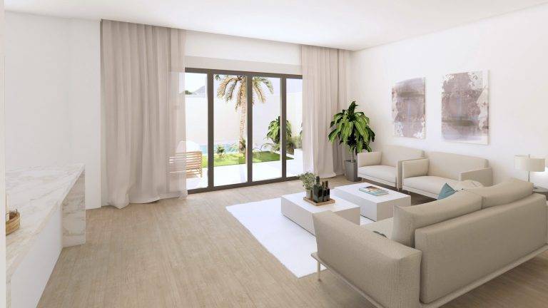 Sala de estar luminosa y moderna, con grandes ventanales que dan al jardín privado, muebles en tonos neutros y decoración minimalista. La imagen resalta la amplitud y el diseño contemporáneo del espacio.