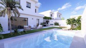 Vista de una piscina en un patio moderno con plantas, muebles de exterior y una casa blanca al fondo bajo un cielo azul.