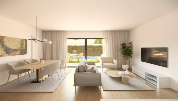 Interior de una vivienda moderna y luminosa, con un diseño abierto que incluye una sala de estar y un comedor. Grandes ventanales permiten el paso de luz natural y ofrecen vistas al jardín privado.