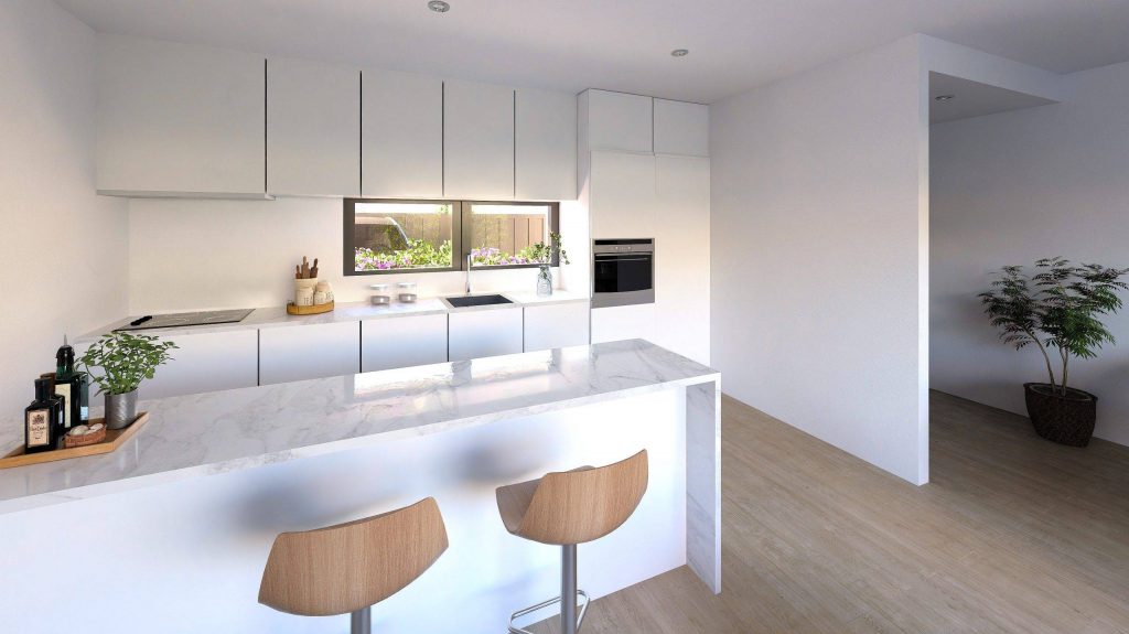 Cocina moderna y luminosa con barra desayunadora y electrodomésticos integrados, diseñada para ofrecer comodidad y estilo en un ambiente de una planta. Elementos decorativos y plantas añaden un toque acogedor al espacio.