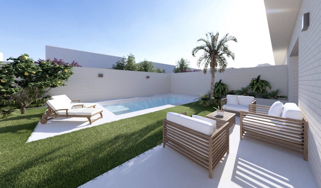 Espacio exterior con piscina, rodeado de césped y plantas, que incluye muebles de jardín en un ambiente luminoso y acogedor. Ideal para disfrutar de momentos al aire libre.