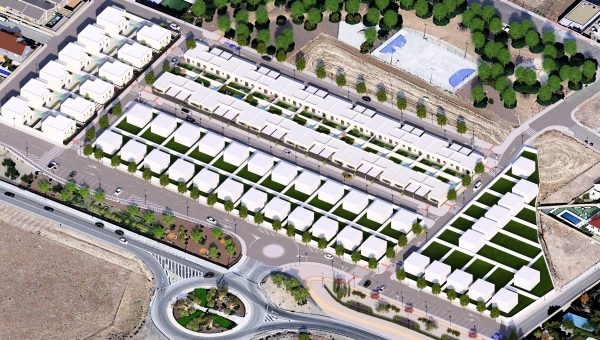 Vista aérea de un conjunto residencial en Poblete, mostrando casas organizadas en filas y áreas verdes. El entorno combina naturaleza y urbanismo, destacando la cercanía a la ciudad de Ciudad Real.